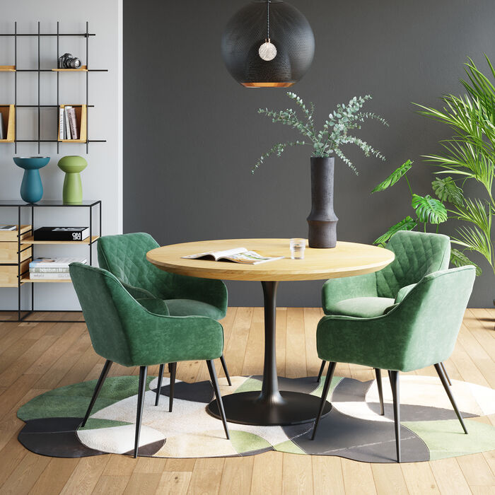 Magnifique chaise design et tendance avec accoudoirs style velours Bretagne vert et piètement noir de la marque Kare Design exposé dans une salle à manger autour d'une table ronde en bois avec une plante