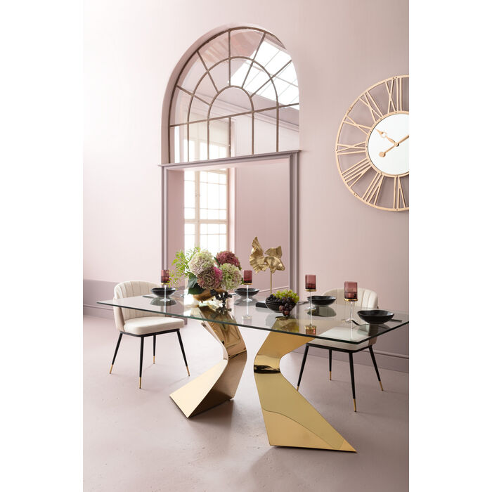 Magnifique table rectangulaire en verre couleur gold Gloria de la marque Kare Design exposé dans une salle à manger aux teintes roses avec des chaises design et de la décoration