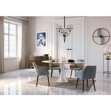 Magnifique chaise tendance look velours Kayla avec accoudoirs de couleur gris et piètement noir exposé dans une salle à manger moderne au sol marbré autour d'une table ronde blanche