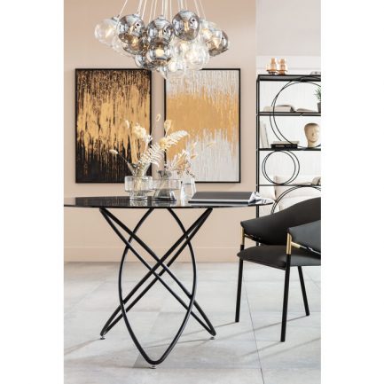 Magnifique table design ronde en verre noir Molekular de la marque Kare Design dans un décor avec une chaise moderne noire et des fleurs posées sur la table