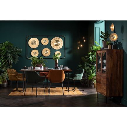 Magnifique chaise en velours Mila de couleur verte de la marque Kare design avec piètement noir exposé dans une salle à manger avec une autre chaise de couleur moutarde