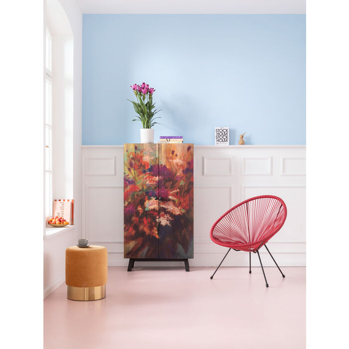 Magnifique pouf tendance style velours Cherry orange en laiton de la marque Kare Design exposé dans un coin coloré avec une chaise rose et une commode