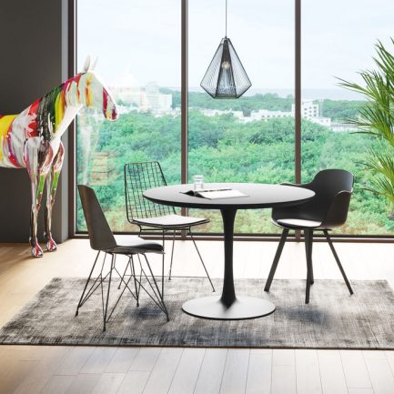 Magnifique petite table simple mais tendance ronde noire Schickeria de la marque Kare Design exposé dans une salle à manger moderne avec un tapis et des chaises