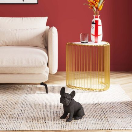 Magnifique figurine décorative tendance qui représente un bébé Bulledog de la marque Kare Design exposé dans un salon coloré et design avec un fauteuil beige et une table basse doré