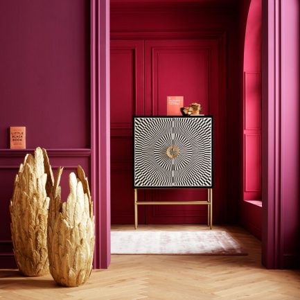 Sublime buffet haut Electro style rétro chic en noir et blanc avec piètement doré de la marque Kare Design exposé dans un coin au mur rose foncé avec de la décoration