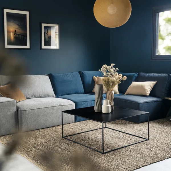 Magnifique table basse au style industriel en métal noir Expo de la marque Zago exposé dans un salon au ton bleu canard et gris avec de la déco
